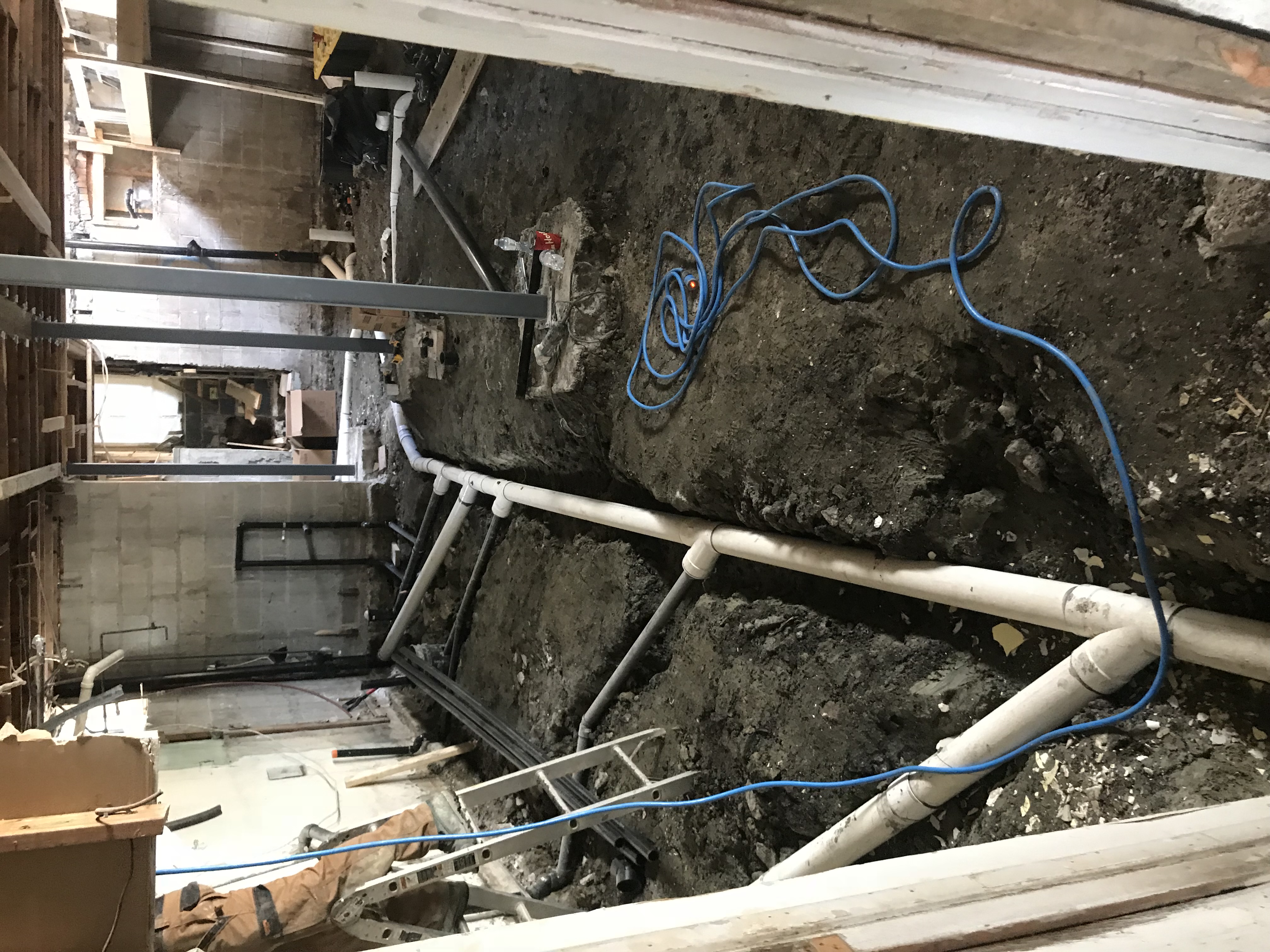 Basement slab opened for new rough-in plumbing and drain layout installation