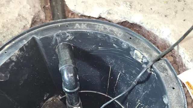 Installed sump pit with sump pump set inside and discharge piping connected