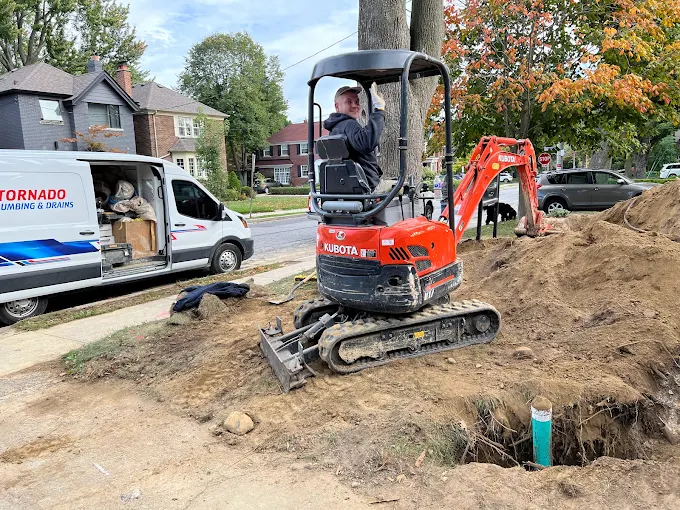 Residential excavation site with mini excavator during underground service-line replacement work